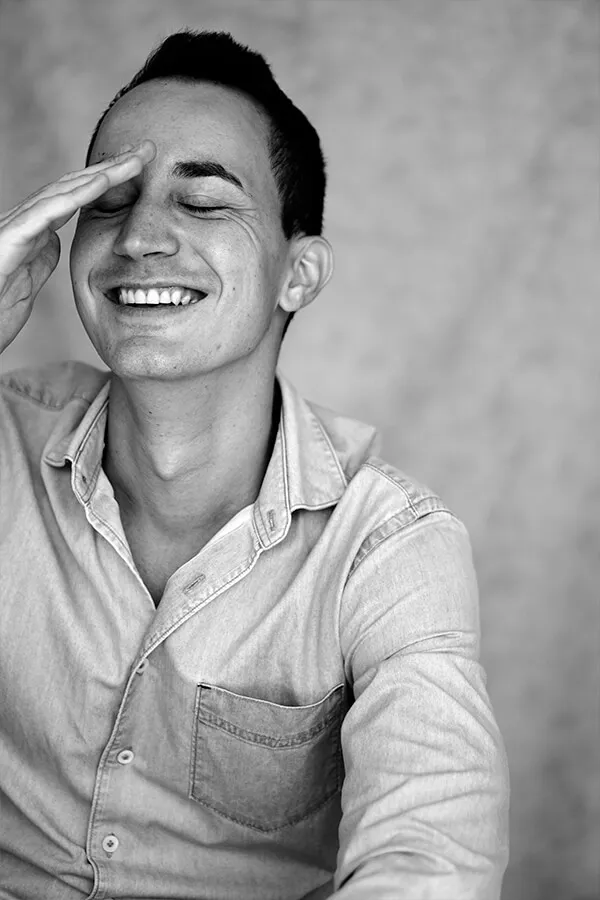 Riendo con la mano en la frente, camisa vaquera, en blanco y negro