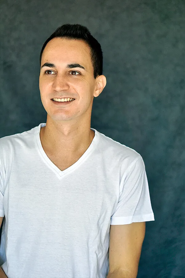 Sonriendo con camiseta blanca sobre fondo verde azulado